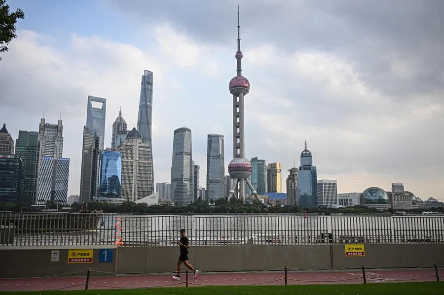 A man runs on the North Bund promenade along the Huangpu river in Shanghai on 27 October 2025. (Jade Gao/AFP)