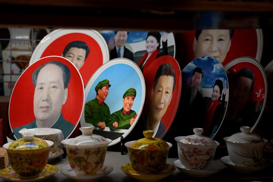 In this file photo taken on 9 November 2021, decorative plates featuring images of China's President Xi Jinping and late communist leader Mao Zedong are displayed at a shop in Beijing, China. (Noel Celis/AFP)