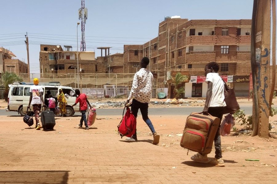 People board a mini-bus as they evacuate southern Khartoum, Sudan, on 14 May 2023. (AFP)