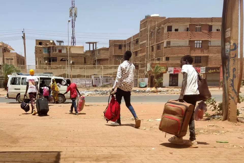 People board a mini-bus as they evacuate southern Khartoum, Sudan, on 14 May 2023. (AFP)