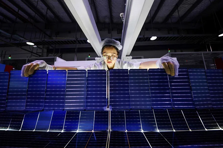 An employee works on solar photovoltaic modules for export at a factory in Sihong, Jiangsu province, China, on 3 September 2024. (STR/AFP)