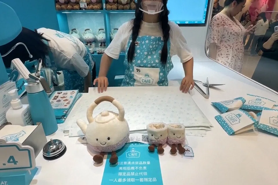 A “barista” wraps teapot and teacup plush toys for a customer at the Jellycat pop-up store in Shanghai, China. (Screen grab from CCTV+)