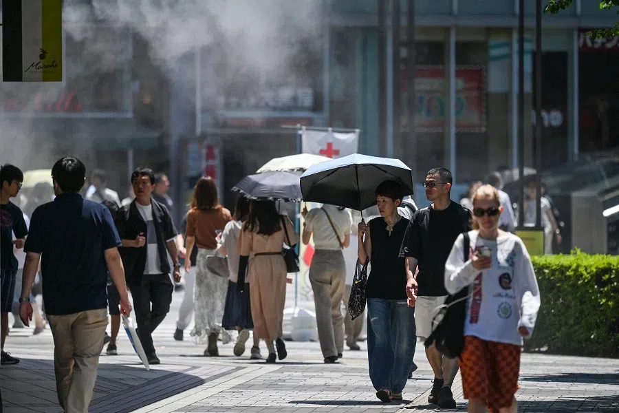 Pedestrians walk along a street in the Yuruakucho area of Tokyo on 16 June 2024. (Richard A. Brooks/AFP)