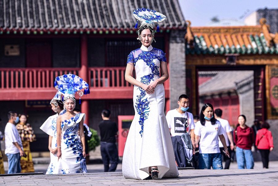 Models display cheongsams, also known as qipaos, during the Shenyang Cheongsam Culture Festival at Shenyang Imperial Palace in Shenyang, Liaoning, China, 23 September 2020. (STR/AFP)