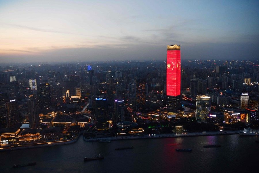 The Chinese flag is seen on a skyscraper in Shanghai at dusk on 31 August 2021, part of celebrations marking the 100th anniversary of the founding of the Chinese Communist Party. (Greg Baker/AFP)