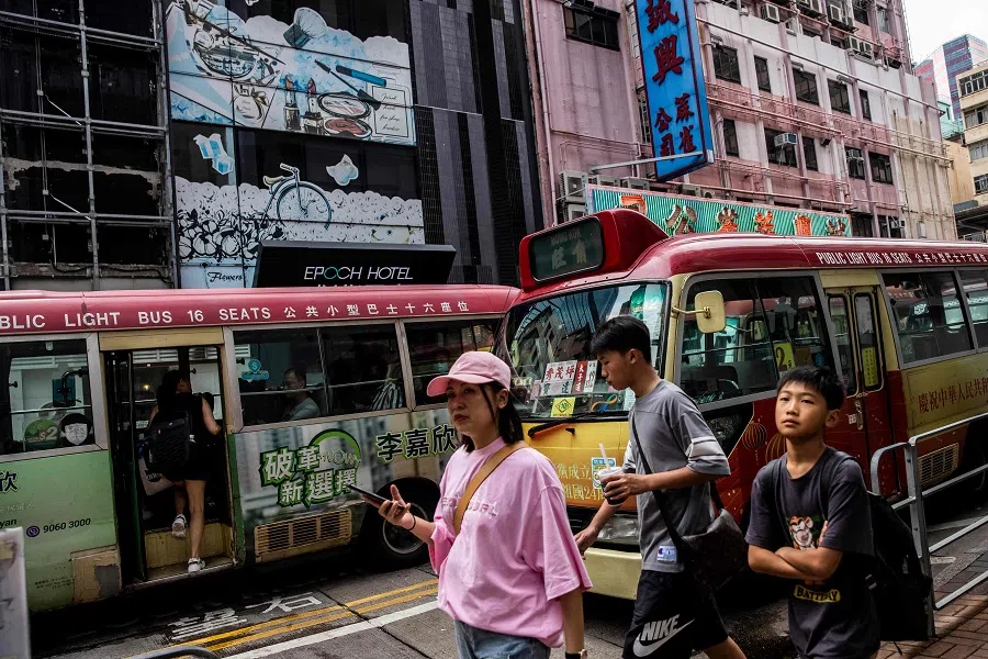 People walk along a street in Hong Kong on 11 August 2023. (Isaac Lawrence/AFP)