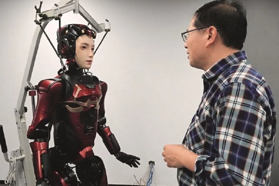 Chen Junmin, general manager of the software and service centre at Digit, engages with a robot on 10 March 2025. (Photo: Du Zhihang/Caixin)