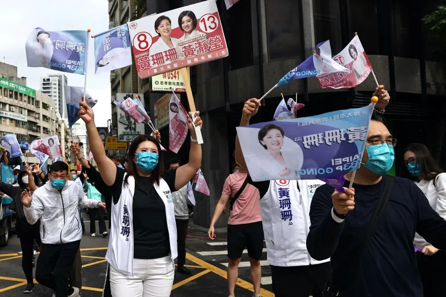 Supporters wave flags to welcome Huang Shan-shan, who ran as an Independent candidate for the mayoral election in Taipei, Taiwan, 25 November 2022. (Ann Wang/Reuters)