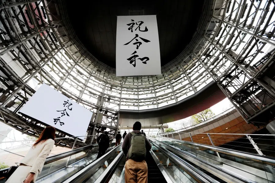 A huge banner and screen celebrating Reiwa, Japan's new imperial era, in a business district in Tokyo. The traditional announcement written in calligraphy style in both printed and digital form is juxtaposed in a modern-day setting. (Reuters)