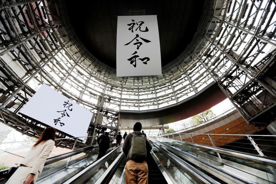 A huge banner and screen celebrating Reiwa, Japan's new imperial era, in a business district in Tokyo. The traditional announcement written in calligraphy style in both printed and digital form is juxtaposed in a modern-day setting. (Reuters)