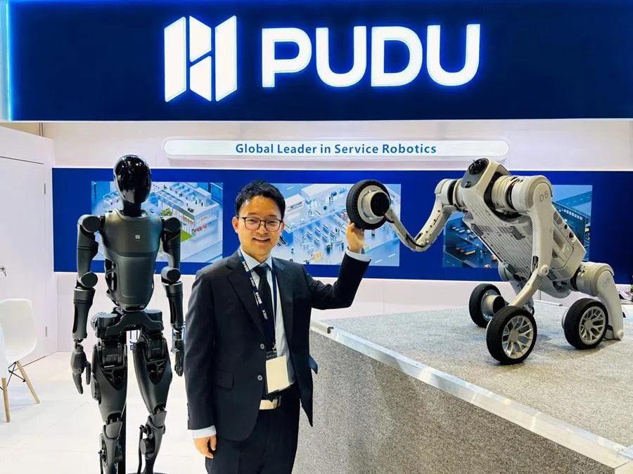 Pudu Robotics founder Zhang Tao is pictured with the company’s humanoid robot PUDU D9 and robotic dog PUDU D5.