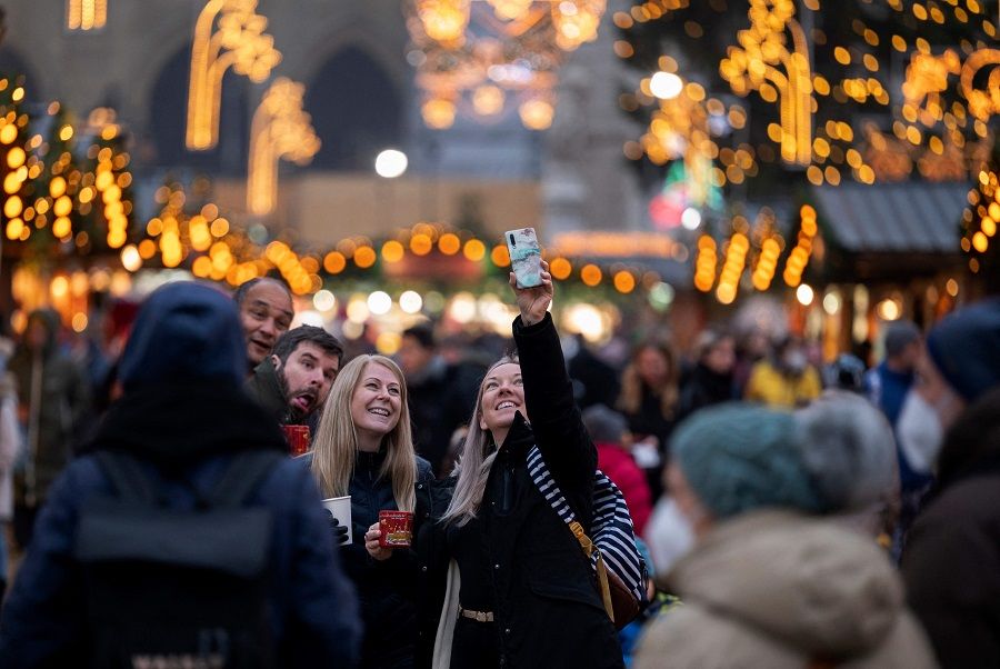 Visitors take selfies at the traditional annual Christmas Market outside of Vienna's city hall in Vienna, Austria on 15 November 2021. (Joe Klamar/AFP)