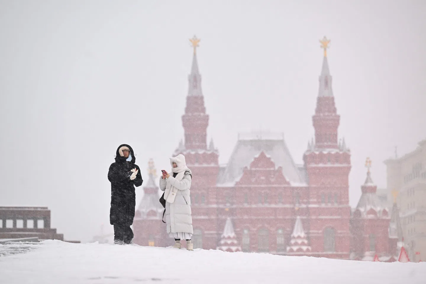 Tourists visit Red Square, with the mausoleum of the Soviet Union founder Vladimir Lenin and the State Historical Museum seen in distance, during a heavy snowfall in Moscow on 7 February 2024. (Natalia Kolesnikova/AFP)