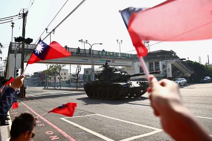 People wave Taiwan flags while soldiers driving M60 tanks pass on a street as part of a military drill in Taichung, Taiwan, 3 November 2020. (Ann Wang/File Photo/Reuters)