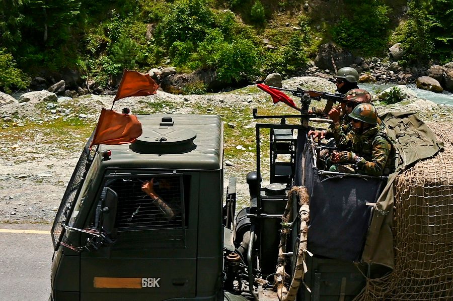 Indian army soldiers ride in a convoy along a highway leading towards Leh, bordering China, in Gagangir on 17 June 2020. (Tauseef Mustafa/AFP)