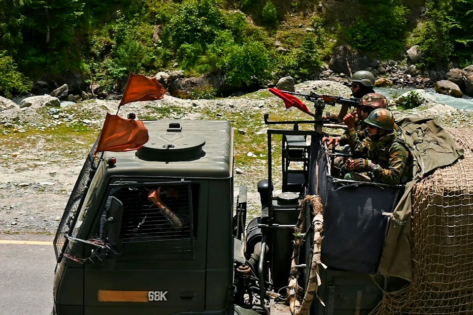 Indian army soldiers ride in a convoy along a highway leading towards Leh, bordering China, in Gagangir on 17 June 2020. (Tauseef Mustafa/AFP)