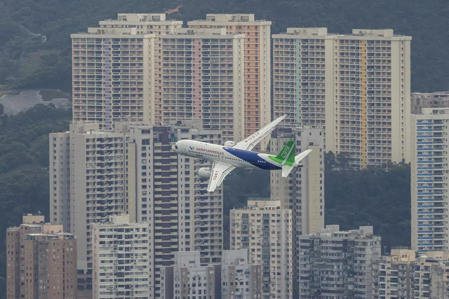 China’s first domestically manufactured passenger aircraft COMAC C919 flies over Victoria Harbour in Hong Kong during its inaugural voyage outside the mainland on 16 December 2023. (Tyrone Siu/Reuters)