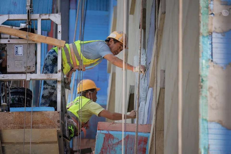 Men work at a construction site of apartment buildings in Beijing, China, 15 July 2022. (Thomas Peter/Reuters)