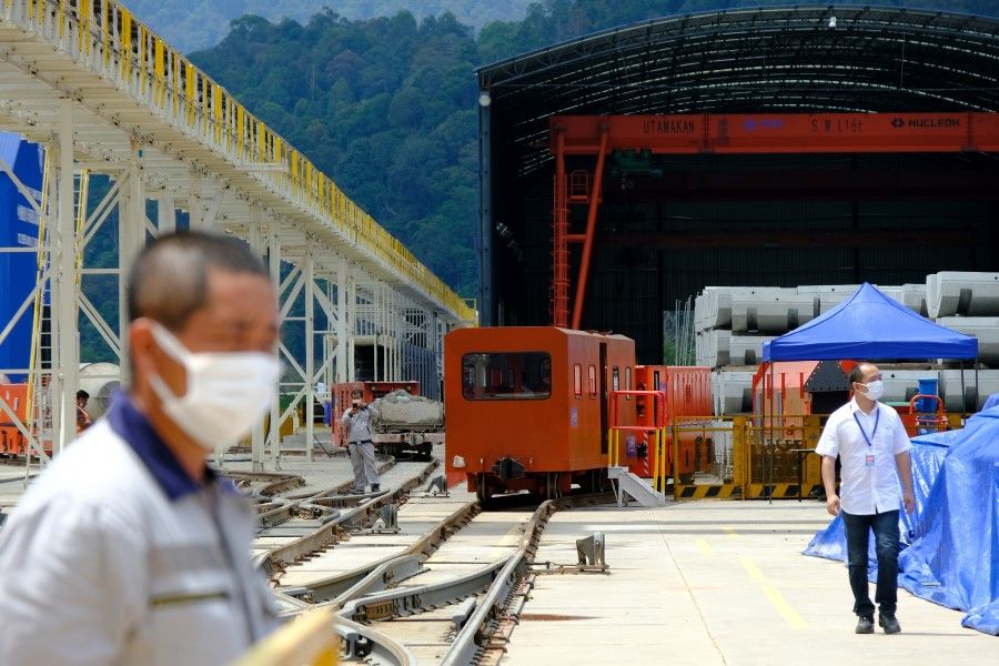 Workers in front of shipping containers at the Genting tunnel construction site, part of the East Coast Rail Link (ECRL) project built by China Communications Construction Co., in Bentong, Pahang, Malaysia, on 23 June 2022. (Samsul Said/Bloomberg)