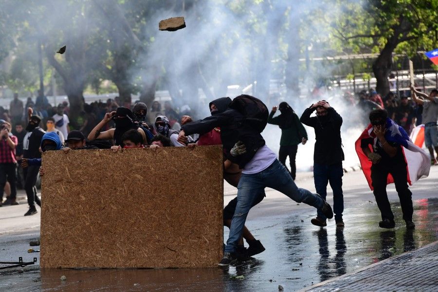 Demonstrators clash with riot police in Santiago, Chile, during protests against government economic policies. Chile cancelled hosting the APEC summit due to civil unrest. (Martin Bernetti/AFP)
