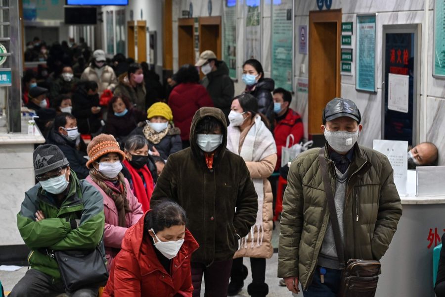 People wearing face masks to help stop the spread of a deadly virus which began in the city, wait for medical attention at Wuhan Red Cross Hospital in Wuhan on 25 January 2020. (Hector Retamal/AFP)