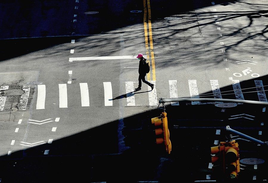A person crosses the street on 27 March 2020 in New York City. (Angela Weiss/AFP)