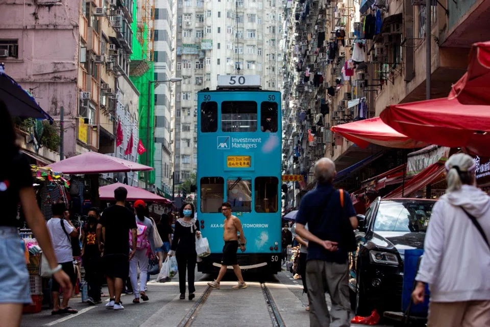 A tram makes its way through a street market in the North Point district of Hong Kong on 5 November 2021. (Isaac Lawrence/AFP)