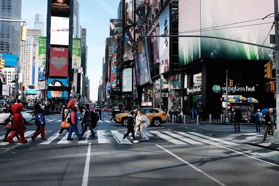 People walk through Times Square on 11 March 2022 in New York City, US. (Spencer Platt/Getty Images/AFP)