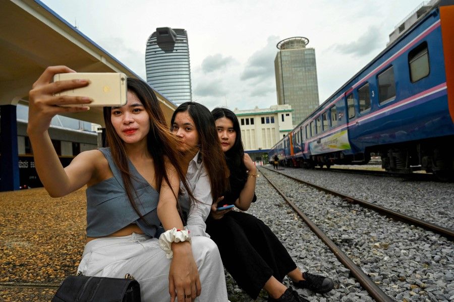Posing for a selfie next to a train at a railway station in Phnom Penh. (Tang Chhin Sothy/AFP)
