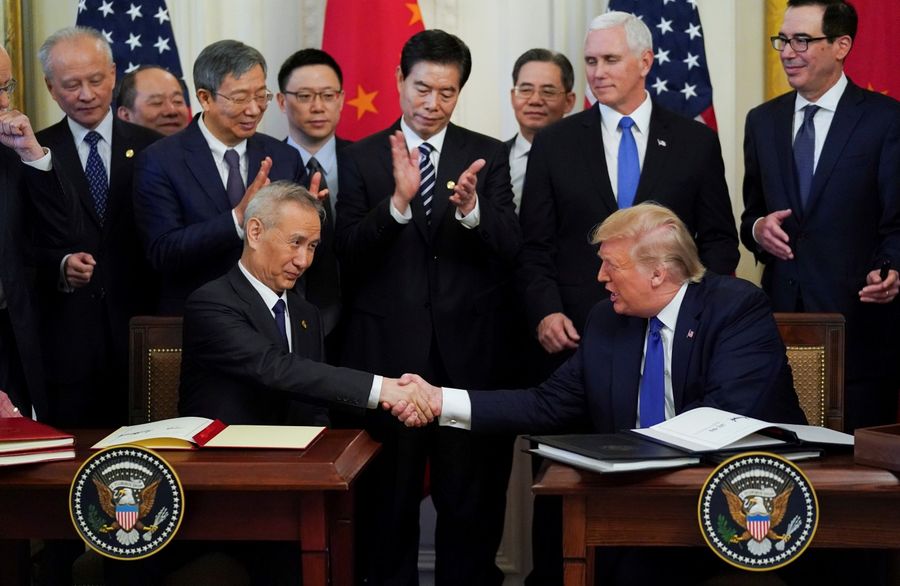 Chinese Vice Premier Liu He and US President Donald Trump shake hands after signing phase one of the US-China trade agreement. The phase one trade deal is a win-win for both China and the US. (Kevin Lamarque/Reuters)