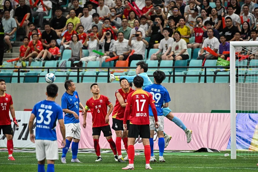 Players jostle for the ball during a match at the Kunshan Olympic Sport Center in Kunshan, in eastern China’s Jiangsu province on 29 June 2025. (Hector Retamal/AFP)