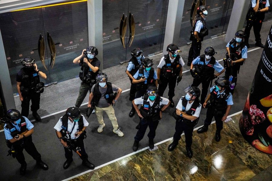 Police stand guard at a mall after people were protesting for press freedom in Kong on 11 August 2020. (Isaac Lawrence/AFP)