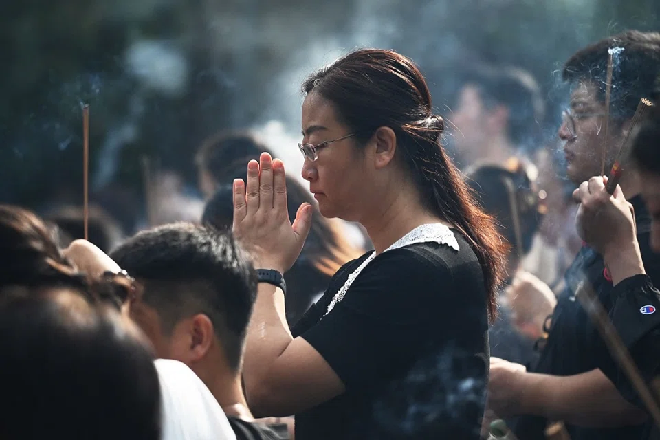 People burn incense as they offer prayers at the Lama Temple in Beijing, China, on 17 September 2024. (Greg Baker/AFP)