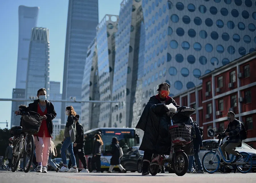 People walk along a street in Beijing, China, on 12 October 2021. (Noel Celis/AFP)