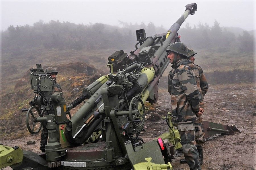 Indian Army soldiers stand next to a M777 Ultra Lightweight Howitzer positioned at Penga Teng Tso ahead of Tawang, near the Line of Actual Control (LAC), neighbouring China, in India's Arunachal Pradesh state on 20 October 2021. (Money Sharma/AFP)