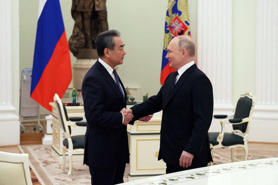 Russia's President Vladimir Putin shakes hands with China's Director of the Office of the Central Foreign Affairs Commission Wang Yi during a meeting in Moscow, Russia, 22 February 2023. (Anton Novoderezhkin/Sputnik/Pool via Reuters)