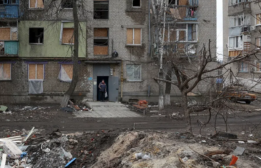 A local resident stands in the doorway of a building partially destroyed by Russian shelling in Kupiansk, Kharkiv region, Ukraine, on 7 March 2023. (Anatolii Stepanov/AFP)