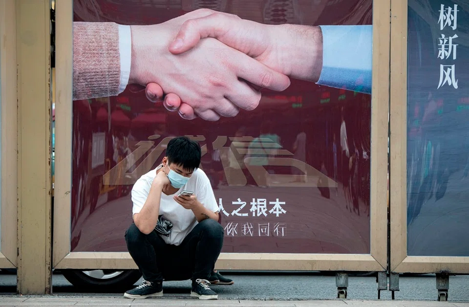 A man uses his phone outside Beijing Railway Station in Beijing on 19 August 2020. (Noel Celis/AFP)