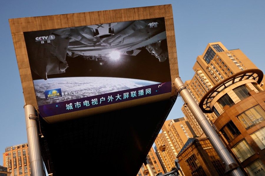 A giant screen shows a view of earth from the Tianhe core module of China's space station, at a shopping mall in Beijing, China, 18 June 2021. (Thomas Peter/Reuters)