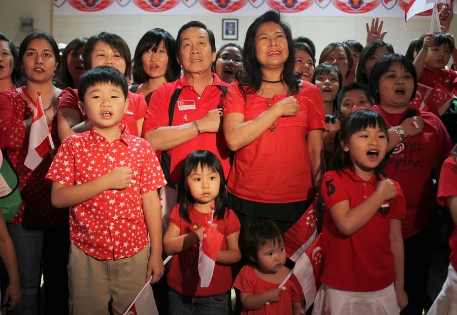 Singaporeans here and all around the world, chimed in with the National Pledge at 8.22 pm Singapore time on 9 August 2009. Singapore's ambassador to China Chin Siat Yoon and his wife Mrs Chin Lee Moi (the couple in the middle) led more than 300 Beijing-based Singaporeans in taking the pledge and cheering as the National Day parade was beamed “live” onto two giant screens in the Singapore embassy in the Chinese capital on 9 August 2009. (SPH Media)
