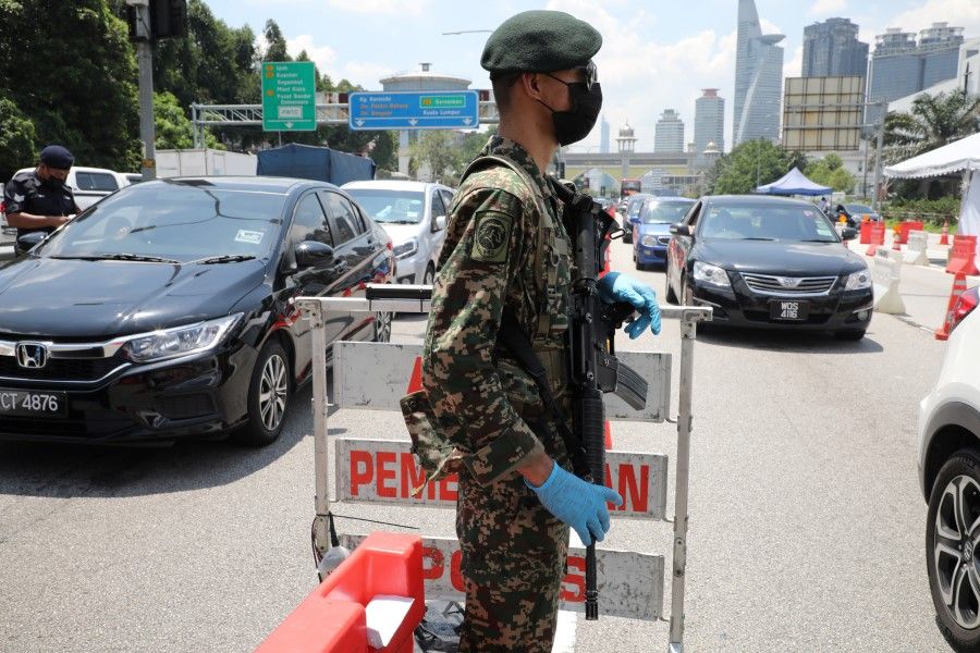 A soldier stands guard at a roadblock during lockdown ahead of the Eid al-Fitr celebrations in an effort to prevent a large-scale transmission of the coronavirus disease (Covid-19), in Petaling Jaya, Malaysia, 10 May 2021. (Lim Huey Teng/Reuters)