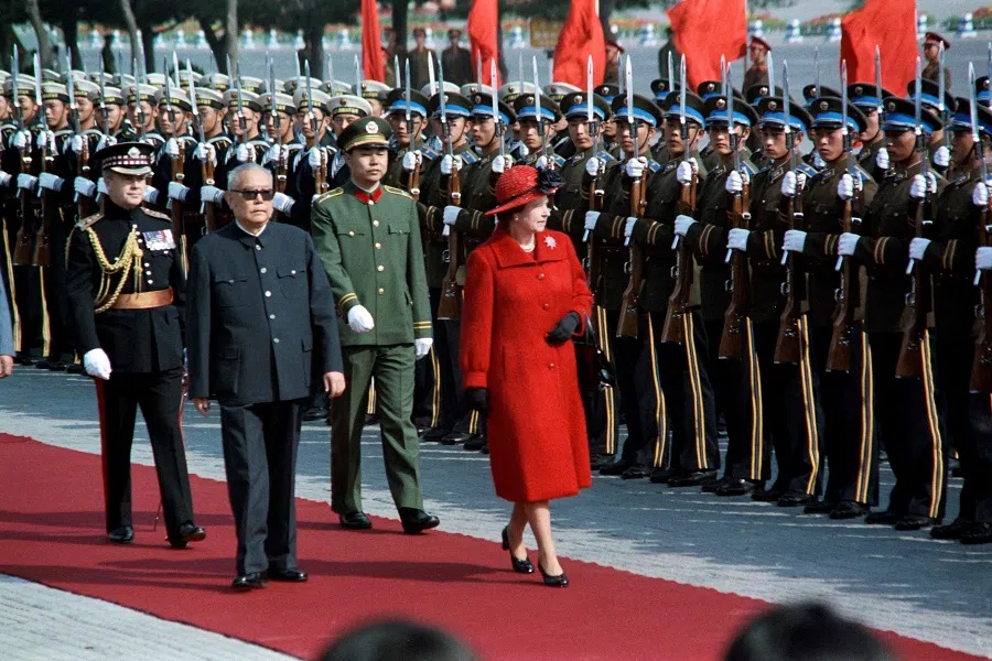 In this file photo taken on 13 October 1986, Britain's Queen Elizabeth II reviews an honour guard after being greeted by Chinese President Li Xiannian in Beijing, China. (Walter Landholt/AFP)