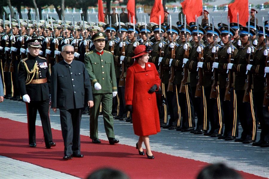 In this file photo taken on 13 October 1986, Britain's Queen Elizabeth II reviews an honour guard after being greeted by Chinese President Li Xiannian in Beijing, China. (Walter Landholt/AFP)