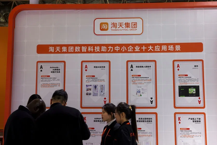 People stand in front of a Taobao and Tmall Group display at the Alibaba booth during the first China International Supply Chain Expo (CISCE) in Beijing, China, on 28 November 2023. (Florence Lo/Reuters)