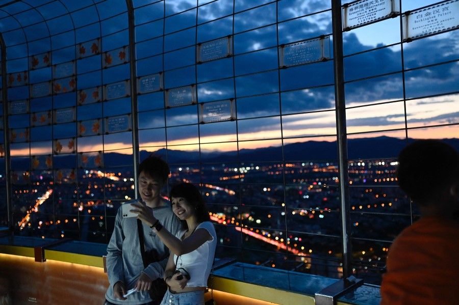 A couple takes a selfie at the Central Television Tower in Beijing on 26 August 2021. (Jade Gao/AFP)