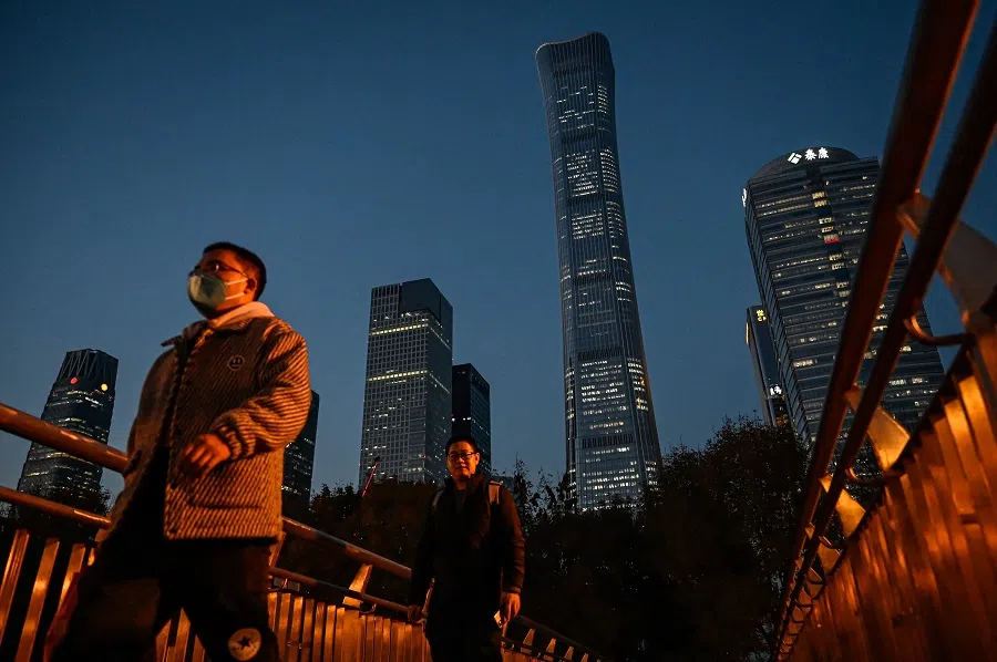 People walk across an overpass at the central business district in Beijing, China, on 14 November 2023. (Jade Gao/AFP)