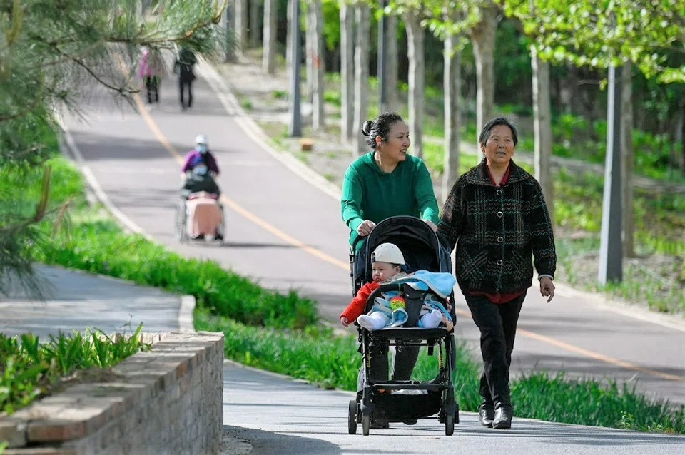 People walk in a public park in Beijing, China, on 15 April 2023. (Wang Zhao/AFP)