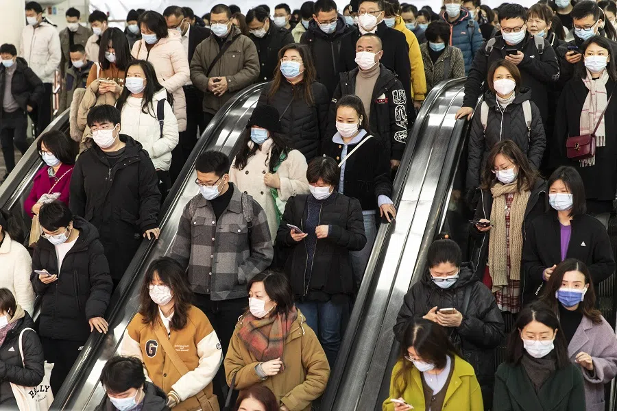 Commuters ride on an escalator at a subway station in Shanghai, China, on 17 December 2021. (Qilai Shen/Bloomberg)