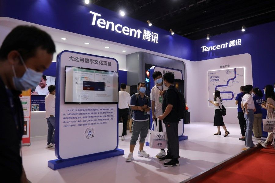 People are seen at a booth of Tencent at an exhibition during China Internet Conference in Beijing, China, 13 July 2021. (Tingshu Wang/Reuters)