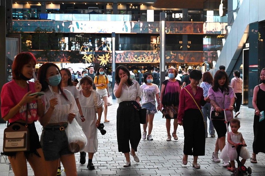People walk in a shopping mall in Beijing on 21 June 2021. (Greg Baker/AFP)